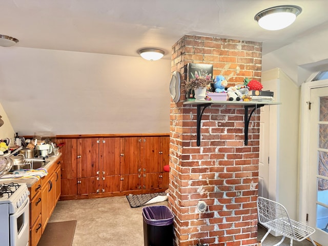 91 Washburn Ave, Portland, ME 04102 - kitchen with white range with gas stovetop, wood walls, wainscoting, and lofted ceiling