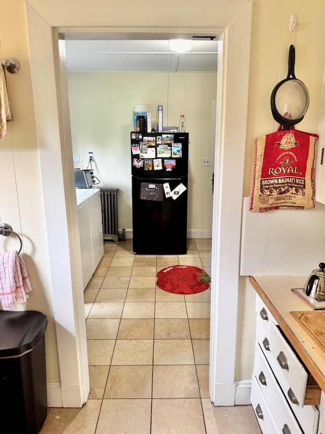 91 Washburn Ave, Portland, ME 04102 - kitchen with freestanding refrigerator, washing machine and clothes dryer, light tile patterned flooring, and white cabinets