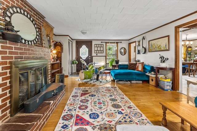 153 Shaker Rd, Gray, ME 04039 - living room with crown molding, wood finished floors, a fireplace, and a chandelier