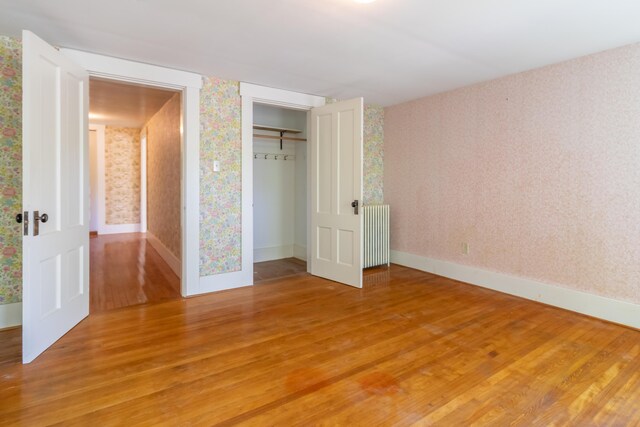 10 Joslyn St, Newport, ME 04953 - unfurnished bedroom featuring wallpapered walls, light wood-style floors, radiator, baseboards, and a closet