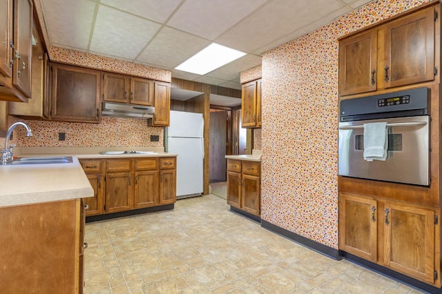10 Joslyn St, Newport, ME 04953 - kitchen with oven, a sink, freestanding refrigerator, under cabinet range hood, and light countertops