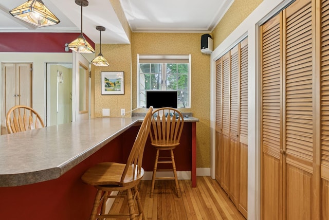 7 Carroll Ave, Auburn, ME 04210 - kitchen with light wood finished floors, a kitchen bar, ornamental molding, hanging light fixtures, and a wall mounted air conditioner