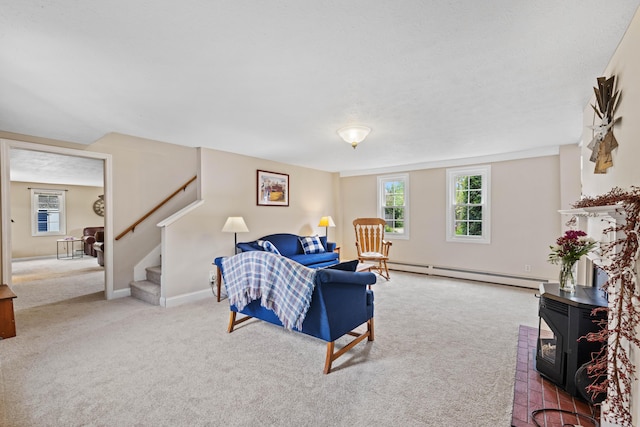 179 Alfred Rd, Kennebunk, ME 04043 - carpeted living area featuring a baseboard radiator, plenty of natural light, stairs, and a wood stove