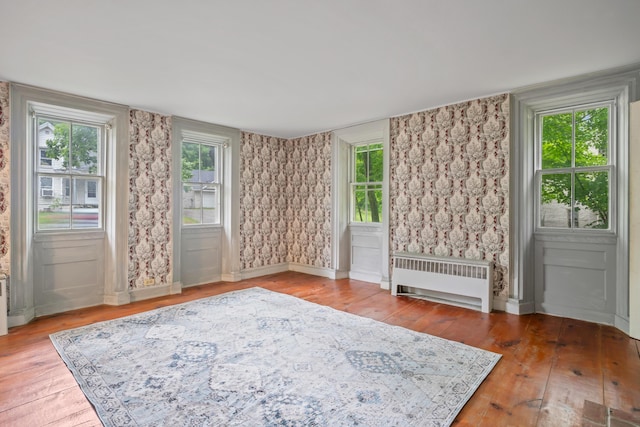 74 Main St, Cornish, ME 04020 - empty room with radiator, wood-type flooring, and healthy amount of natural light
