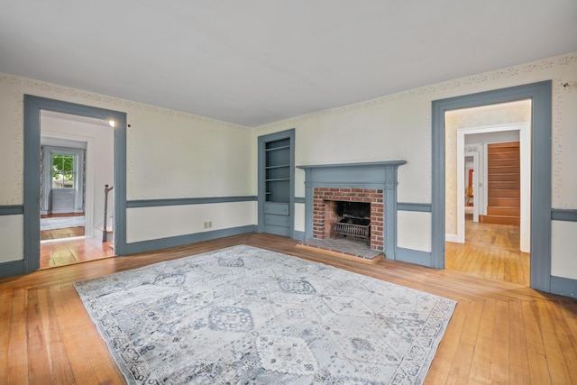 74 Main St, Cornish, ME 04020 - living room featuring built in features, hardwood / wood-style floors, a fireplace, and baseboards