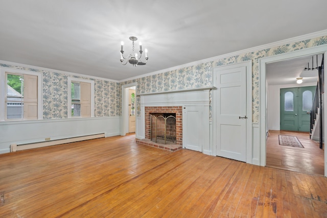 74 Main St, Cornish, ME 04020 - unfurnished living room with a baseboard heating unit, wallpapered walls, wood-type flooring, a chandelier, and a brick fireplace