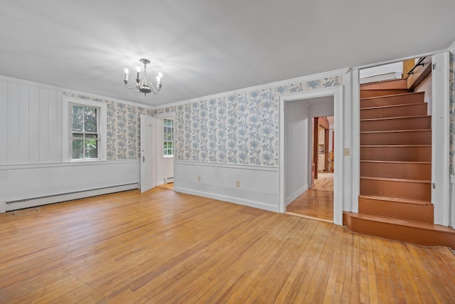 74 Main St, Cornish, ME 04020 - unfurnished living room featuring a chandelier, light wood finished floors, a baseboard heating unit, stairway, and crown molding