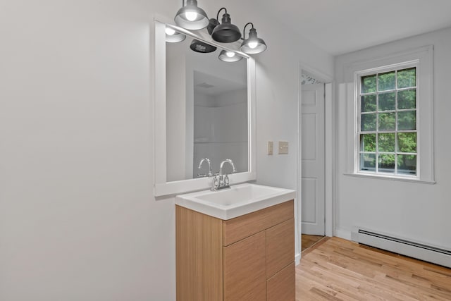 74 Main St, Cornish, ME 04020 - bathroom with a baseboard radiator, vanity, wood finished floors, and a chandelier
