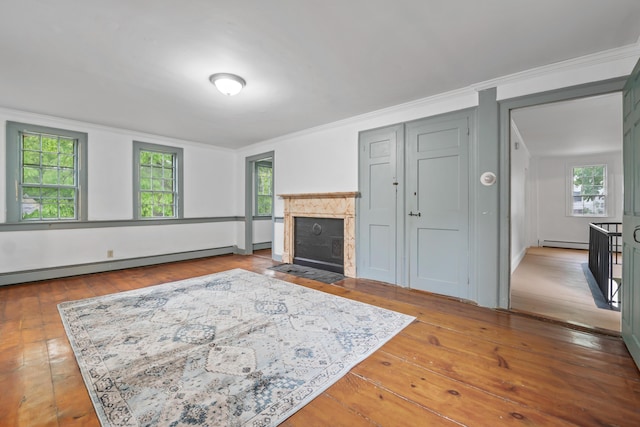 74 Main St, Cornish, ME 04020 - living area with a baseboard radiator, crown molding, wood-type flooring, and a tiled fireplace
