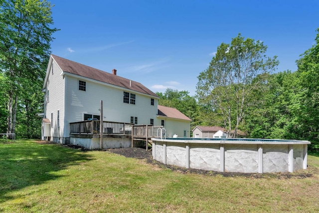 1505 Foxes Ridge Rd, Acton, ME 04001 - rear view of house featuring a wooden deck, a yard, an outdoor pool, and a chimney