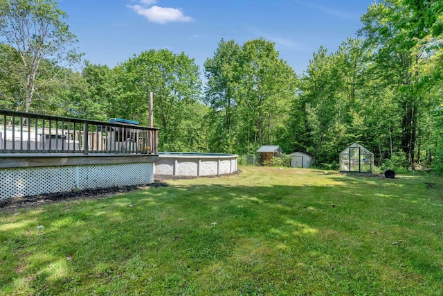 1505 Foxes Ridge Rd, Acton, ME 04001 - view of green lawn featuring an outdoor pool, a storage unit, a wooden deck, and a greenhouse