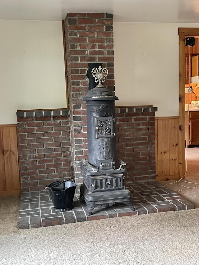 386 Lower Flying Point Rd, Freeport, ME 04032 - detailed view of a wood stove, carpet floors, wainscoting, and wooden walls