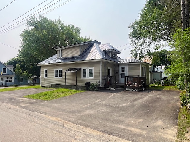 3 Baker St, Winslow, ME 04901 - view of front of home with metal roof, asphalt driveway, and a deck