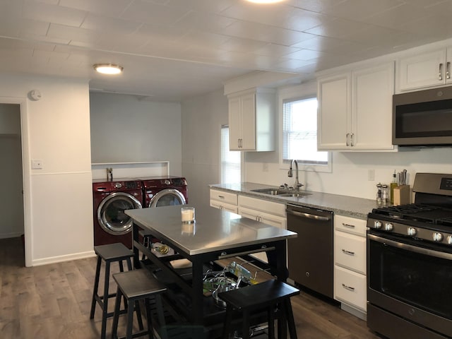 3 Baker St, Winslow, ME 04901 - kitchen featuring appliances with stainless steel finishes, washer and dryer, a sink, and white cabinets