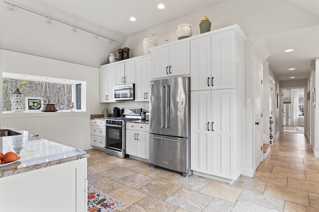 59 Meadow Ln, Ogunquit, ME 03907 - kitchen featuring appliances with stainless steel finishes, stone tile flooring, vaulted ceiling, track lighting, and white cabinets