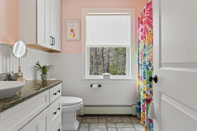 59 Meadow Ln, Ogunquit, ME 03907 - full bath featuring a baseboard radiator, wainscoting, vanity, toilet, and stone finish flooring