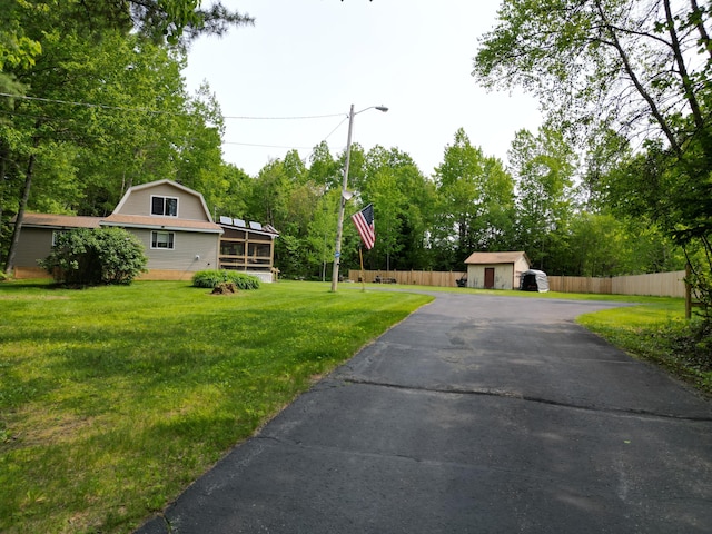 140 Station Rd, Lincoln, ME 04457 - view of yard featuring driveway, an outdoor structure, a sunroom, and view of wooded area