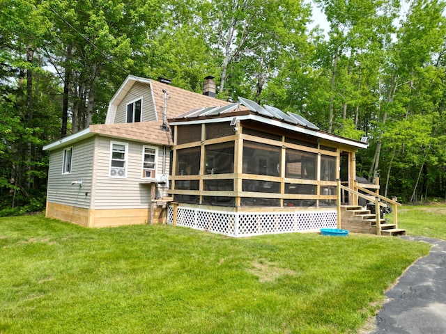 140 Station Rd, Lincoln, ME 04457 - back of property featuring a sunroom, roof with shingles, a gambrel roof, and a yard