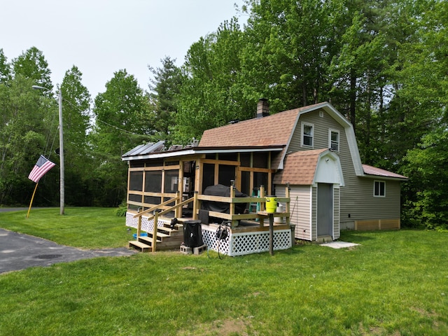 140 Station Rd, Lincoln, ME 04457 - back of property with a sunroom, a chimney, a lawn, a gambrel roof, and a shingled roof