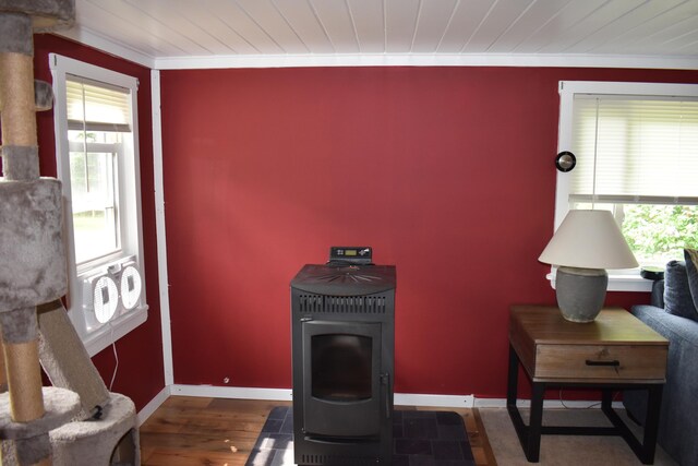 140 Station Rd, Lincoln, ME 04457 - living area with a wood stove, baseboards, wood finished floors, ornamental molding, and wooden ceiling