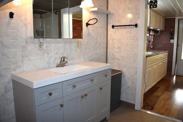 140 Station Rd, Lincoln, ME 04457 - bathroom featuring vanity, tile walls, wood finished floors, and backsplash