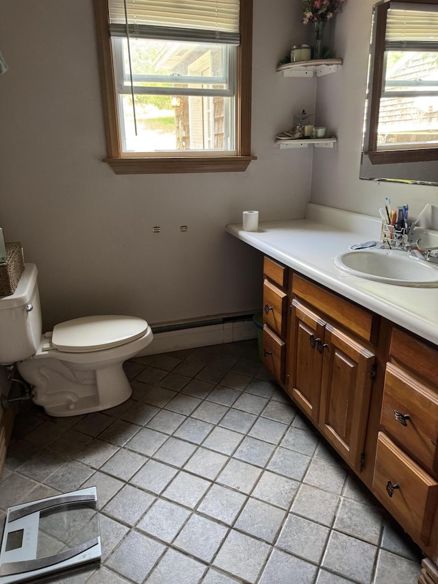 20 Coldbrook Rd, Hampden, ME 04444 - half bathroom with a baseboard radiator, toilet, vanity, and tile patterned flooring