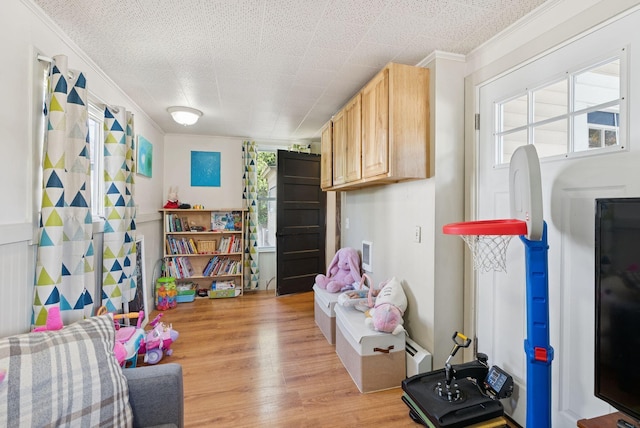 13 Bartlett St, Waterville, ME 04901 - game room with ornamental molding, light wood-type flooring, and a baseboard radiator