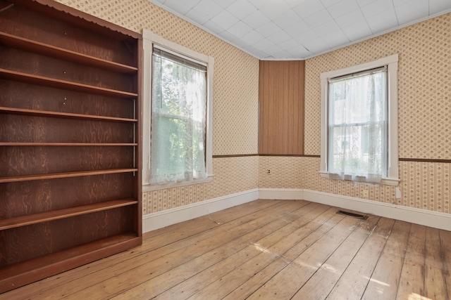 11 Center St, Richmond, ME 04357 - empty room with wallpapered walls, baseboards, light wood-style flooring, healthy amount of natural light, and ornamental molding