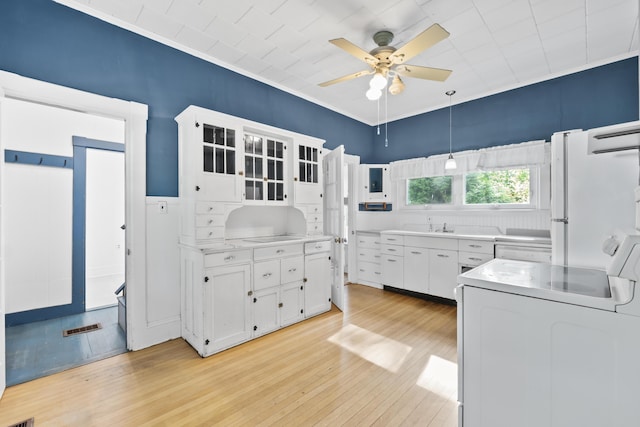 11 Center St, Richmond, ME 04357 - kitchen with ceiling fan, white cabinetry, light wood-type flooring, range, and washer / dryer