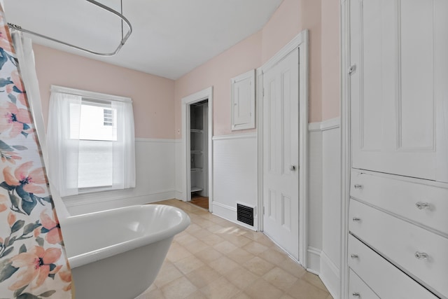 11 Center St, Richmond, ME 04357 - bathroom with wainscoting, a freestanding tub, a closet, and tile patterned floors