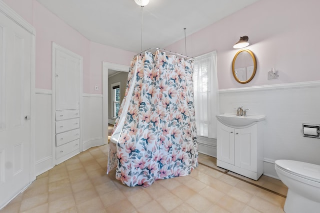 11 Center St, Richmond, ME 04357 - bathroom with curtained shower, tile patterned floors, wainscoting, toilet, and vanity
