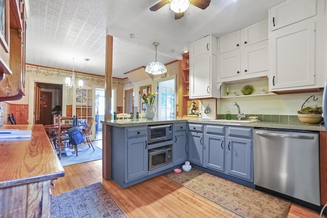 23 Western Ave, Boothbay Harbor, ME 04538 - kitchen with stainless steel appliances, open shelves, a sink, a peninsula, and white cabinets