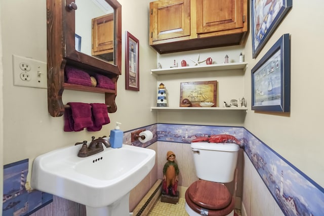 23 Western Ave, Boothbay Harbor, ME 04538 - half bath with a baseboard radiator, toilet, a sink, and wainscoting