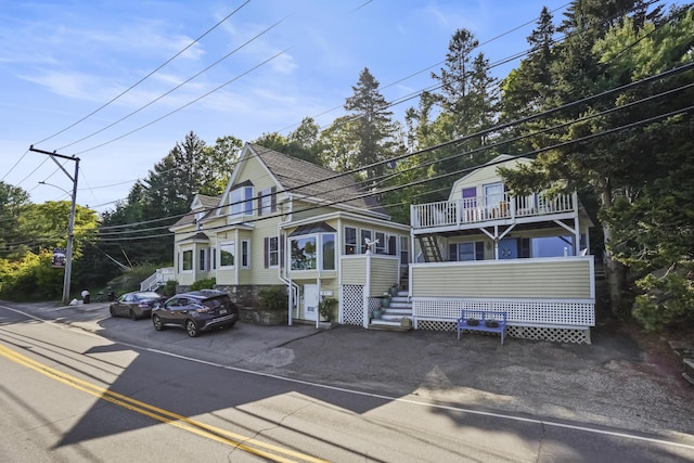 23 Western Ave, Boothbay Harbor, ME 04538 - view of front of property featuring stairs, a shingled roof, and a balcony