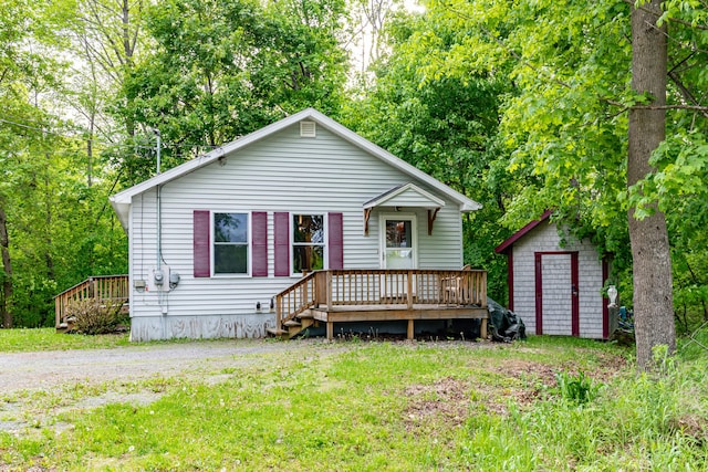 14 Carter Ln, Brewer, ME 04412 - view of front of house featuring a deck, an outdoor structure, and a front lawn