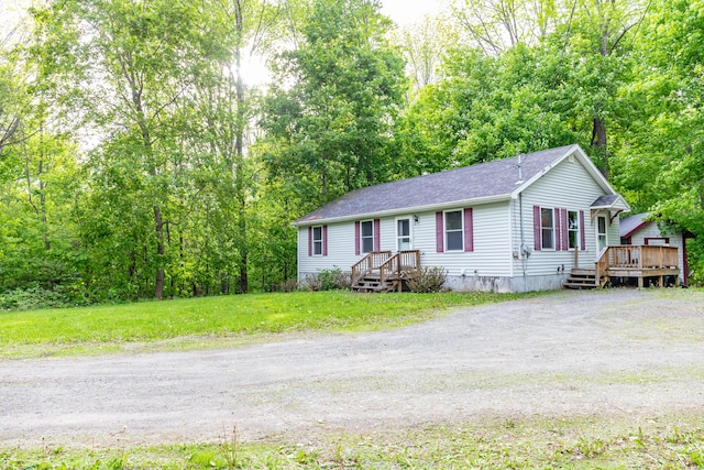 14 Carter Ln, Brewer, ME 04412 - view of front of house featuring a deck, roof with shingles, dirt driveway, and a front yard