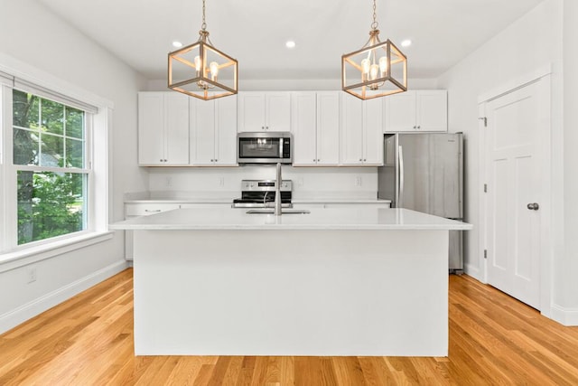 21 Arnies Alley -, Westbrook, ME 04092 - kitchen featuring appliances with stainless steel finishes, a chandelier, light countertops, an island with sink, and recessed lighting