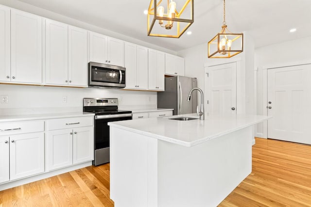 21 Arnies Alley -, Westbrook, ME 04092 - kitchen with stainless steel appliances, a chandelier, a sink, light wood-type flooring, and an island with sink