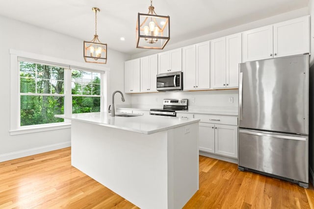 21 Arnies Alley -, Westbrook, ME 04092 - kitchen featuring appliances with stainless steel finishes, a sink, a chandelier, light countertops, and an island with sink