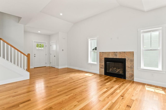 21 Arnies Alley -, Westbrook, ME 04092 - unfurnished living room featuring vaulted ceiling, stairs, light wood finished floors, baseboards, and a tiled fireplace