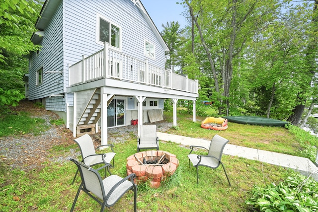 33-34 Gerber Ln, Monmouth, ME 04259 - back of house featuring a fire pit, a deck, and a lawn