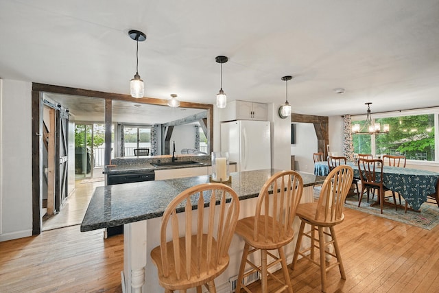 33-34 Gerber Ln, Monmouth, ME 04259 - dining room with healthy amount of natural light, light wood finished floors, and a chandelier