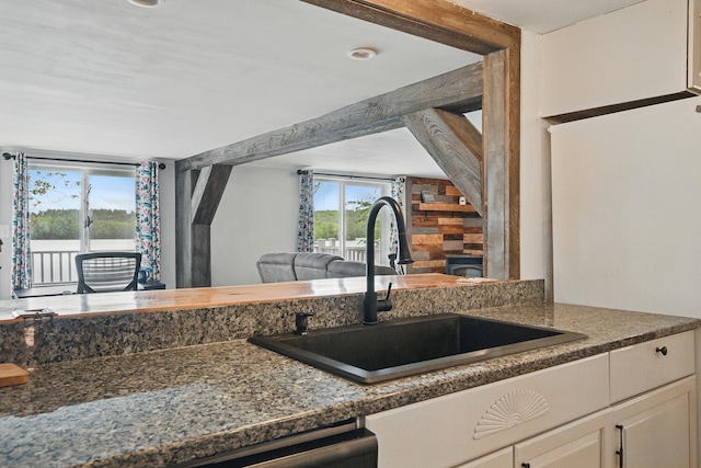 33-34 Gerber Ln, Monmouth, ME 04259 - kitchen with healthy amount of natural light, open floor plan, dark countertops, and white cabinets