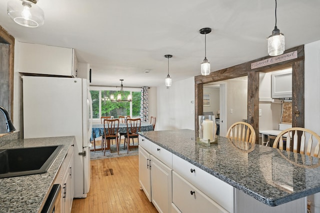 33-34 Gerber Ln, Monmouth, ME 04259 - kitchen featuring white cabinetry, light wood-type flooring, a center island, decorative light fixtures, and freestanding refrigerator