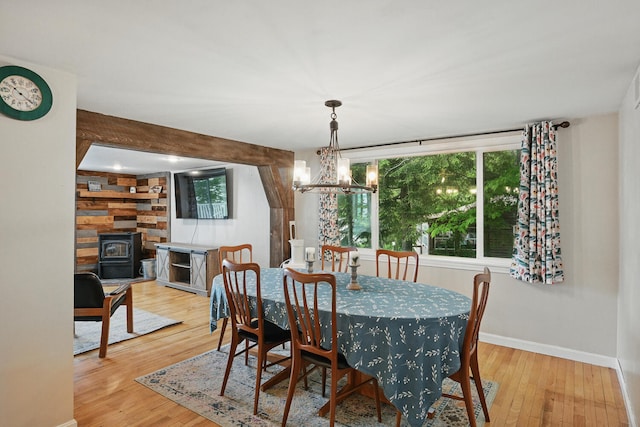 33-34 Gerber Ln, Monmouth, ME 04259 - dining space featuring wood finished floors, a chandelier, and a wood stove