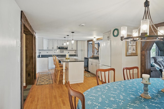 33-34 Gerber Ln, Monmouth, ME 04259 - dining area featuring light wood-type flooring and a chandelier