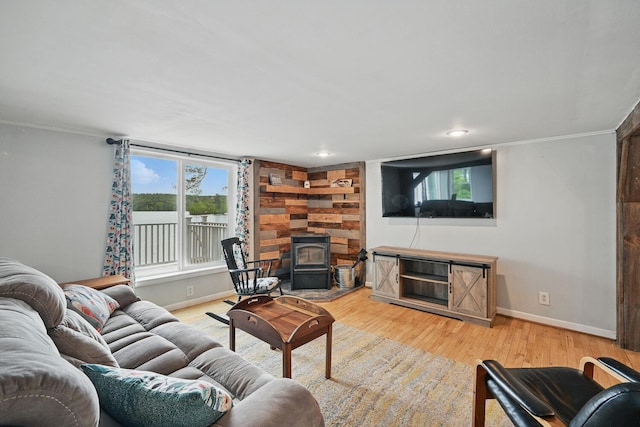 33-34 Gerber Ln, Monmouth, ME 04259 - living room featuring a wood stove, wood finished floors, and ornamental molding
