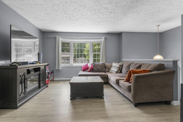 7 Dumas St, Lisbon, ME 04252 - living area with a textured ceiling, a baseboard radiator, and light wood finished floors