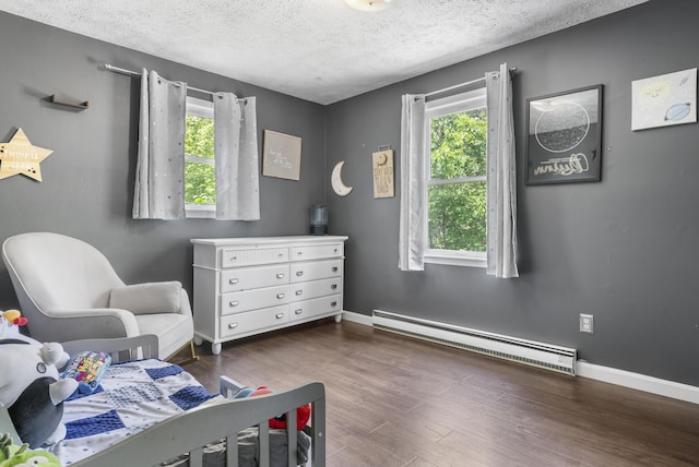 7 Dumas St, Lisbon, ME 04252 - bedroom with a baseboard radiator, multiple windows, wood finished floors, and a textured ceiling