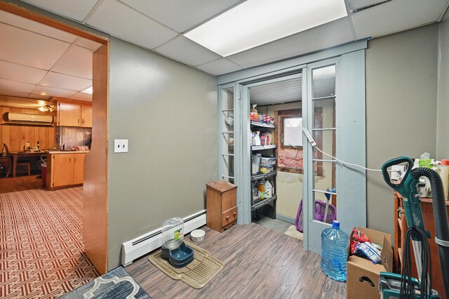 23 Main St, Athens, ME 04912 - interior space featuring a baseboard radiator, a paneled ceiling, wood finished floors, and a wall mounted AC